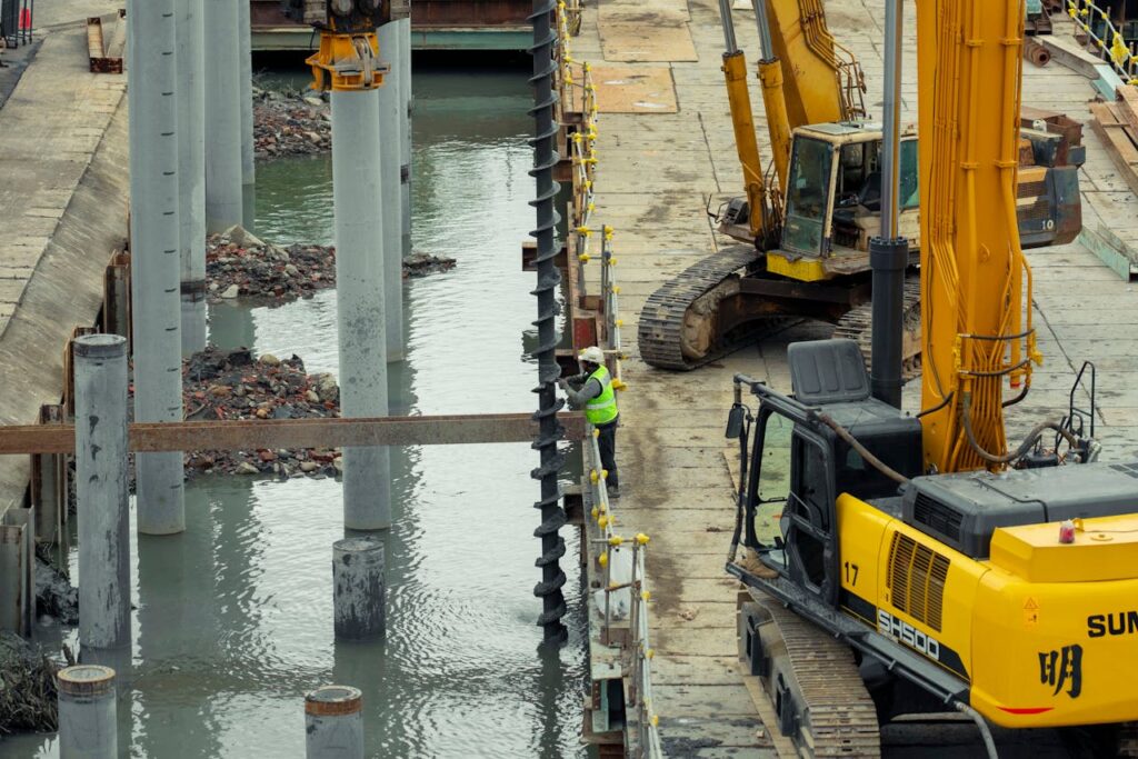 A construction site in Taipei, Taiwan, featuring heavy machinery and a worker on site.