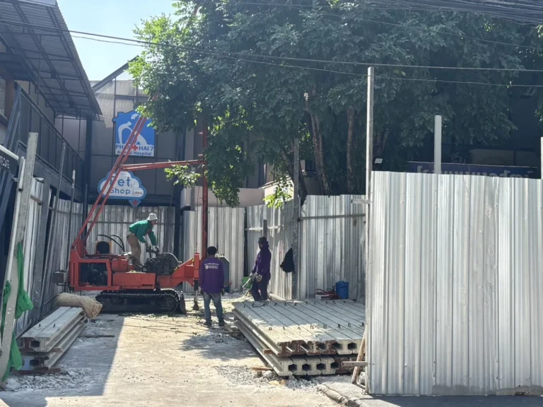 Compact micropile rig positioned in a narrow gap beside the hospital wall